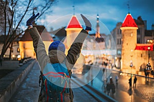 Tallinn, Estonia. Young Lady Woman Enjoying Life And Holding Hands Up Near Famous Landmark Viru Gate In Lighting At