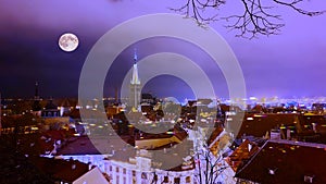 Tallinn old town at blue night full moon on blue sky blurring light on city horizon panorama