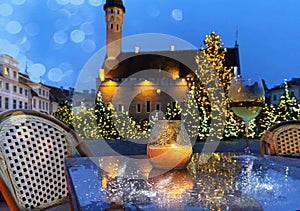 Tallinn Old town  Christmas tree street cafe glass of champagne and yellow light of candle at table top winter in T