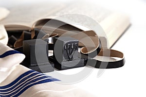 Tallit and tefillin and Torah on white background. Space for text