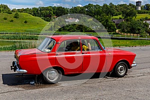 Talsi, Latvia - July 28, 2017: Old vintage red soviet car moskvitch driving