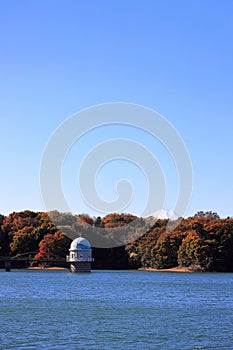 Tama lake and intake tower with Mt. Fuji in autumn