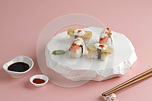 Tamago and Crabstick Roll Sushi on White Oriental Plate, Pink Background