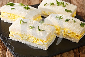 Tamago Sando is a very humble snack, modest, low maintenance and very convenient. The Japanese Egg Sandwich close-up on a slate photo