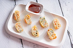 Tamagoyaki or Japanese egg rolls with carrots, spring onion and dashi