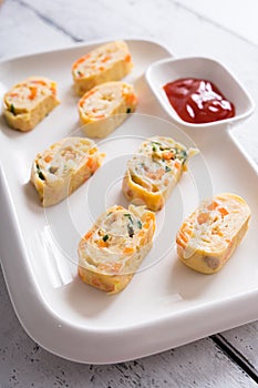 Tamagoyaki or Japanese egg rolls with carrots, spring onion and dashi