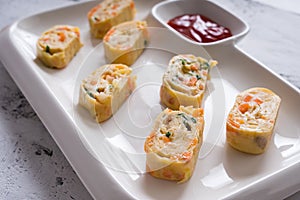 Tamagoyaki or Japanese egg rolls with carrots, spring onion and dashi