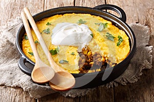 Tamale pie casserole served with sour cream close-up in a pan. horizontal photo