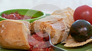 Tamale served with blue corn tortillas and tomato sauce and chili pepper top view