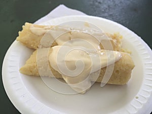 Tamales de elote corn based with cream on top photo