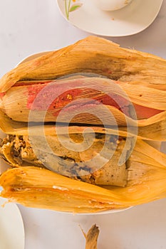 Tamales, typical Mexican food, of different flavors, wrapped in corn leaves. Red chile tamale