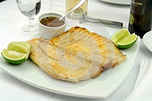 Tambaqui fish ribs, traditional brazilian barbecue whole piece on skewer isolated on white dish.