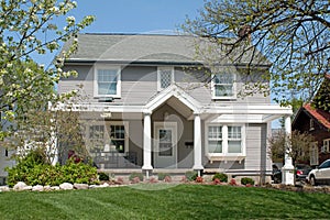 Tan Colonial House in Spring