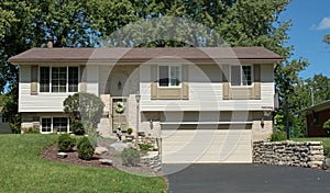 Tan, Split-level House With Lower Garage