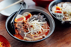 Tan Tan Ramen: Japanese noodle in Tan Tan soup with mince pork, boiled egg, wood ear and sprout in black bowl