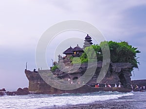 Tanah Lot and sea waves in golden sunset, Bali