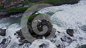 Tanah Lot Temple on the rock in Sea. Ancient hinduism place of worship. Sunlight. Aerial view. Bali, Indonesia