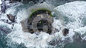 Tanah Lot Temple on the rock in Sea. Ancient hinduism place of worship. Sunlight. Aerial view. Bali, Indonesia