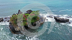 Tanah Lot Temple on the rock in Sea. Ancient hinduism place of worship. Sunlight. Aerial view. Bali, Indonesia