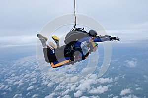 Tandem skydiving in the cloudy sky.