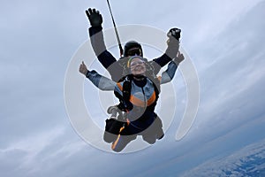 Tandem skydiving in the cloudy sky.