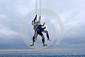 Tandem skydiving in the cloudy sky.