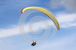 Tandem Paraglider flying in a blue sky