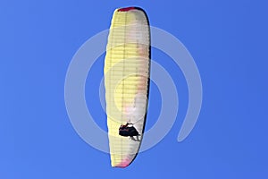 Tandem Paraglider flying in a blue sky