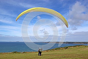 Tandem paraglider launching at Newgale