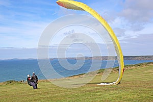 Tandem paraglider launching at Newgale