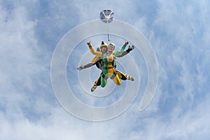 Tandem skydiving. A active girl is flying in the blue sky