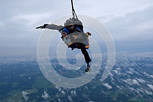 Tandem skydiving in the cloudy sky.