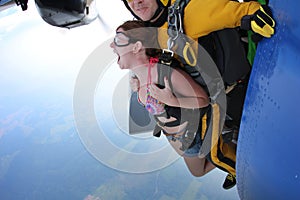 Tandem skydiving. Exit. Girl is screaming.