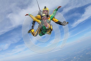 Tandem skydiving. A active girl is flying in the blue sky photo