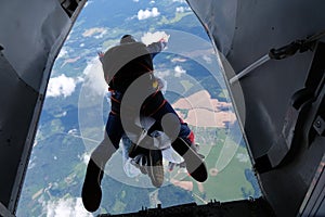 Tandem skydiving. A tandem is jumping out of a plane.