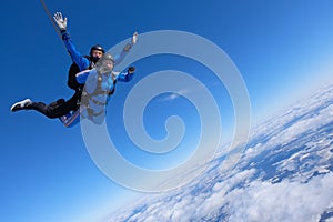Tandem skydiving. Two guys are in the blue sky. photo
