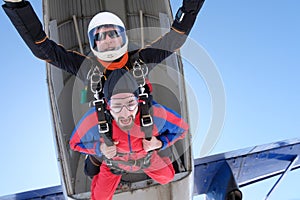 Tandem skydiving. Two happy men are jumping out.