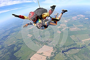 Tandem skydiving. Woman and instructor are flying in the sky.