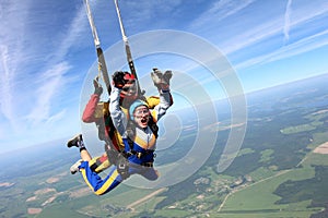 Tandem skydiving. Woman and instructor are in the sky.