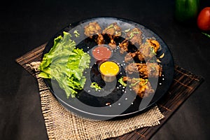 Tandoori Chicken Lollipop with mayo dip chilli sauce served in dish isolated on napkin dark background top view of indian fastfood