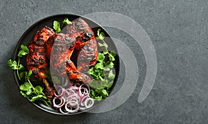 Tandoori chicken served with cilantro and onion