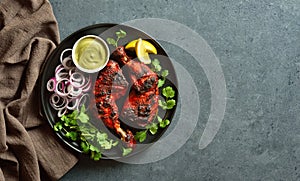 Tandoori chicken served with cilantro and onion