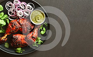 Tandoori chicken served with cilantro and onion