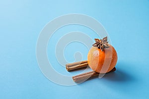 Tangerine on Cinnamon Sticks Imitating Sledges Anise Star Blue Background. Christmas New Year Greeting Card Poster Sales Template. photo