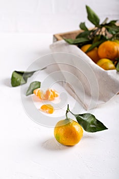 Tangerine clementine, mandarin, citrus fruit with green leaf on white table