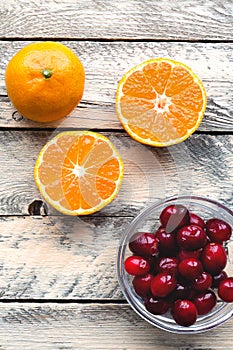 Tangerine and cranberry on wooden table.