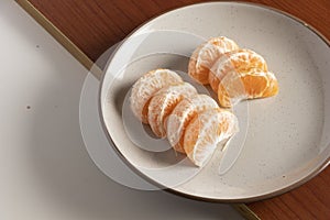 Tangerine hulls on beige plate. Food during a pandemic. Healthy eating of fruits