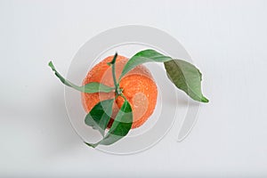 Tangerine with mandarin leaves with drops isolated on a white background.