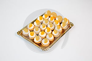 Tangerine and orange cupcakes in a tray on white background