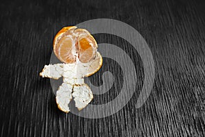 Tangerines on a black background. Lots of fresh fruit - mandarins.